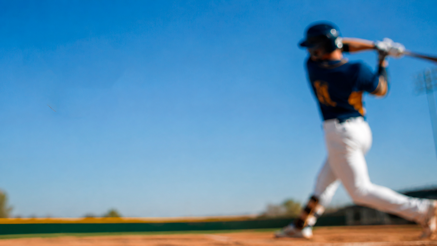 Campo de beisbol con jugador bateando